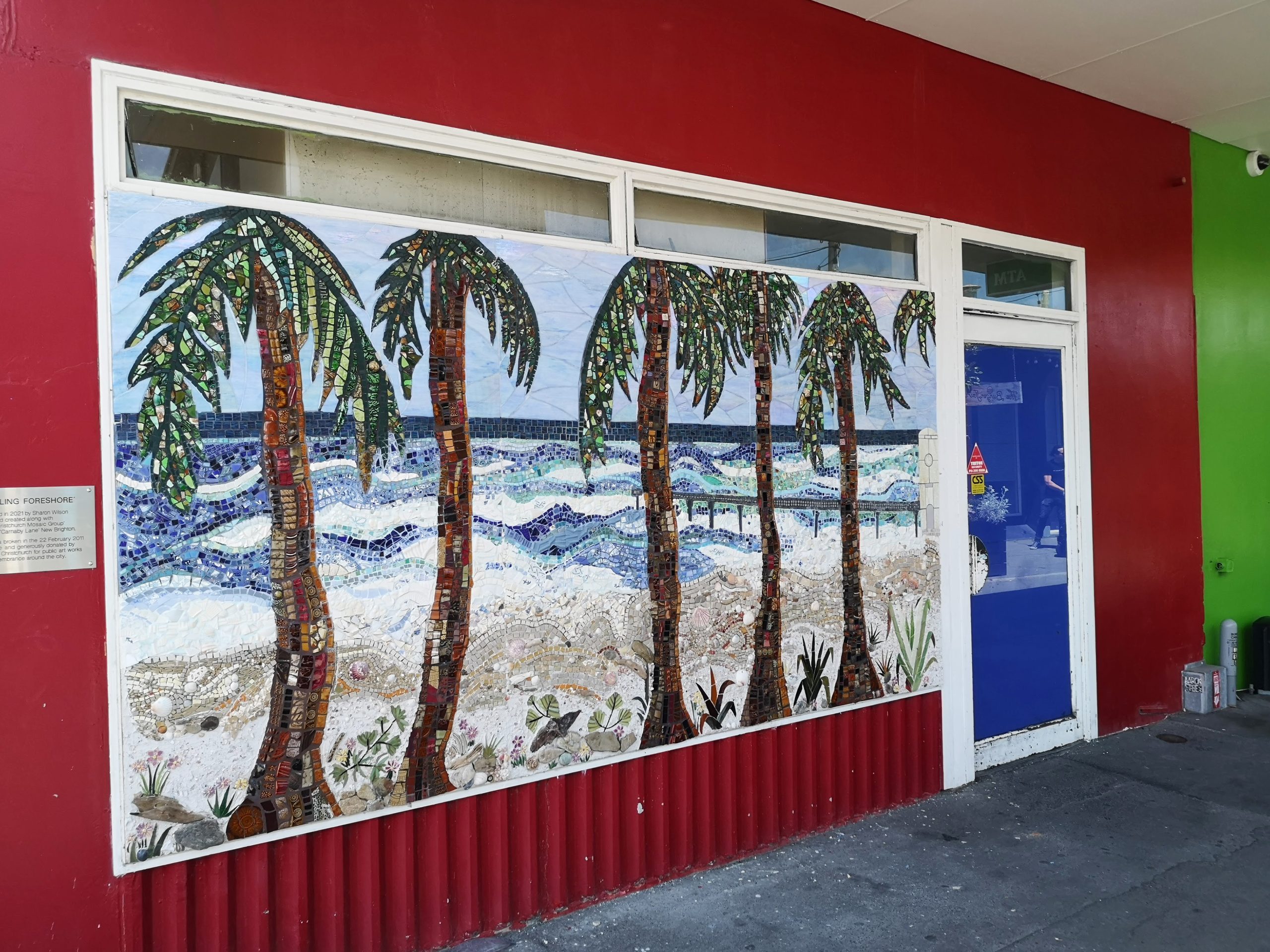 Mosaic mural of palm trees and beach