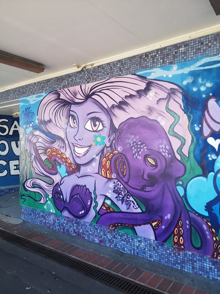 Street art of a purple mermaid and octopus