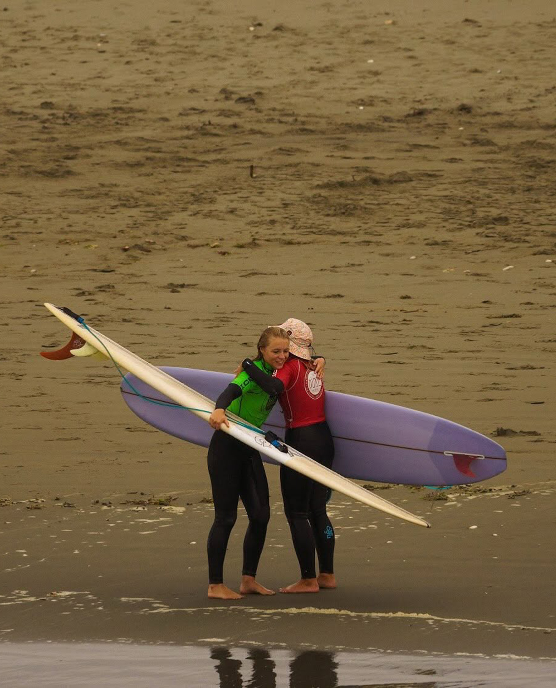 Contestants hugging at the Duke Festival of Surfing